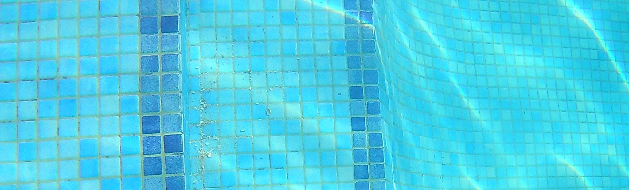 Wide finished view of the underwater tile replacement across the pool steps