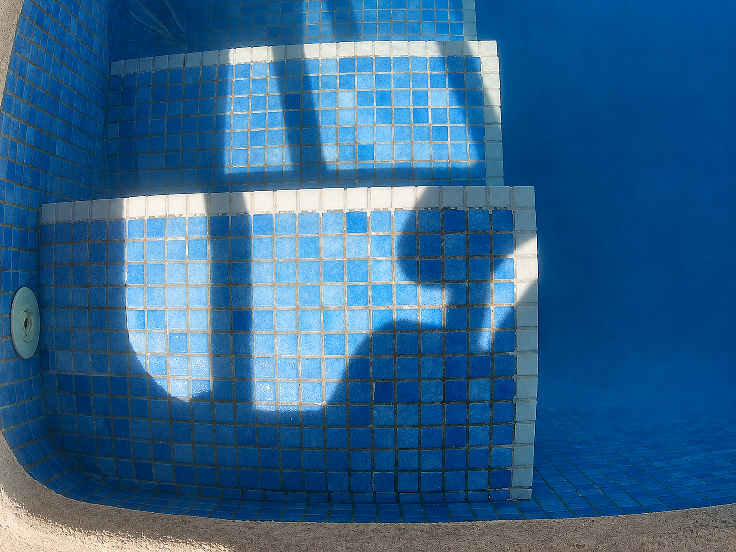 Clear finished view of the repaired white pool step edging in El Alamillo