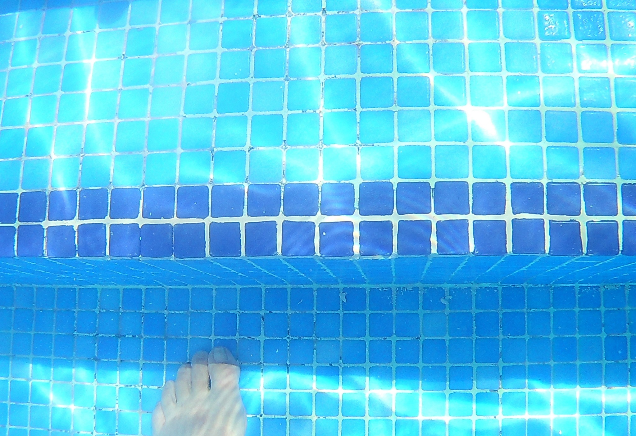 Clear finished view of the retiled and regrouted pool step edge in Hacienda