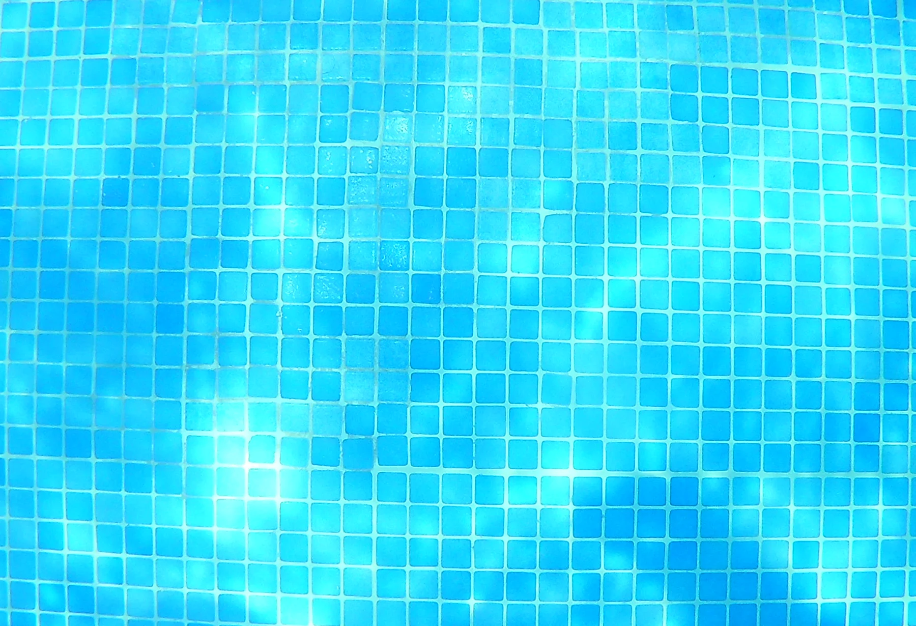 Close view of blue swimming pool mosaic tiles and grout lines
