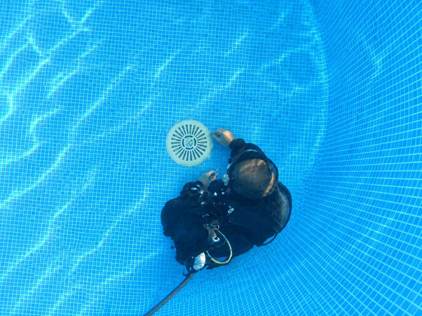 ScubaTile specialist carrying out an underwater pool drain repair